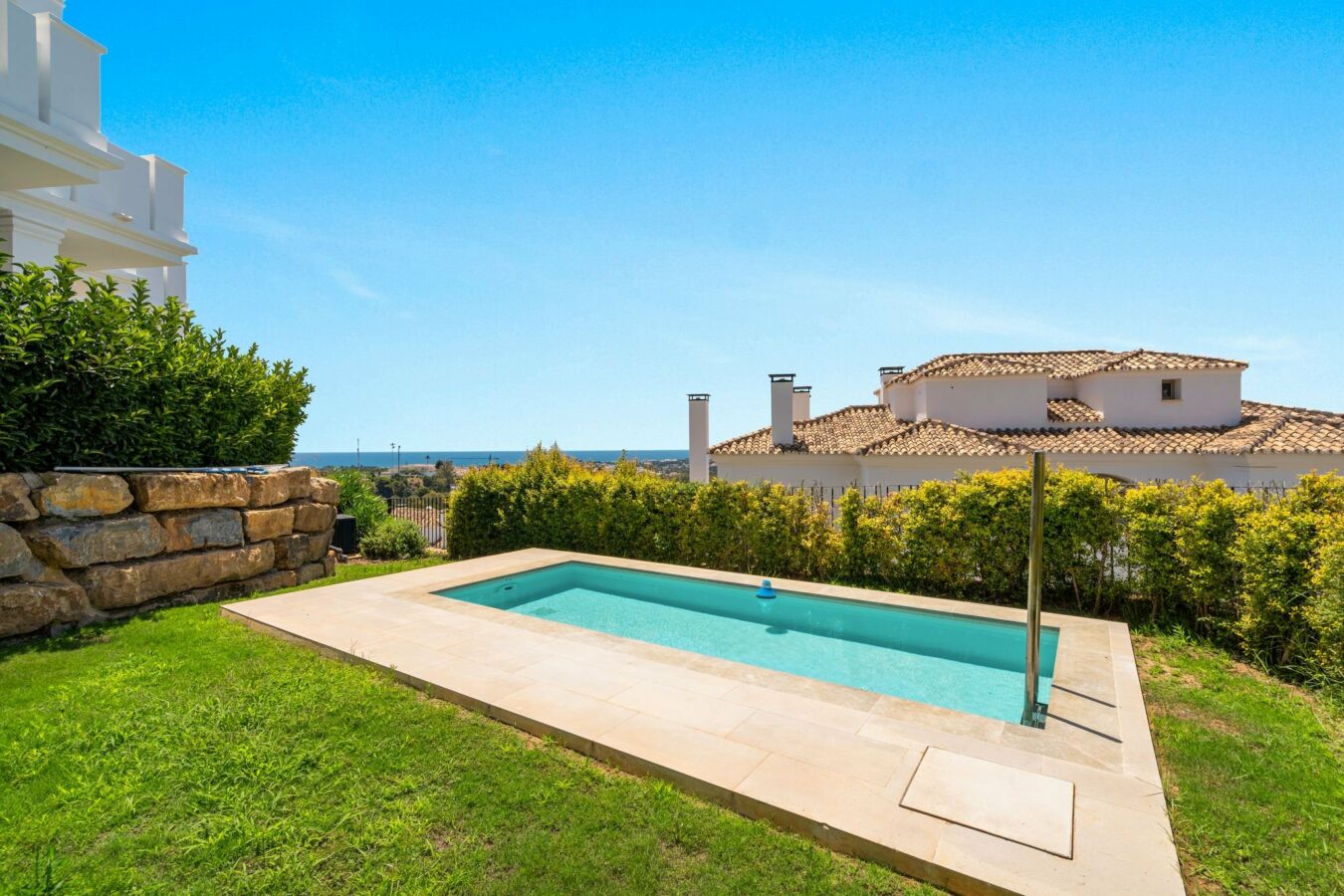 Swimming pool with lawn and sea views
