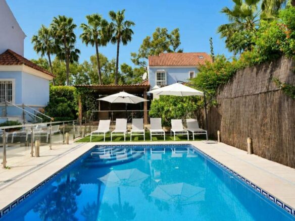 Heated swimming pool, sun loungers and landscaped garden of the Lorea Playa villa