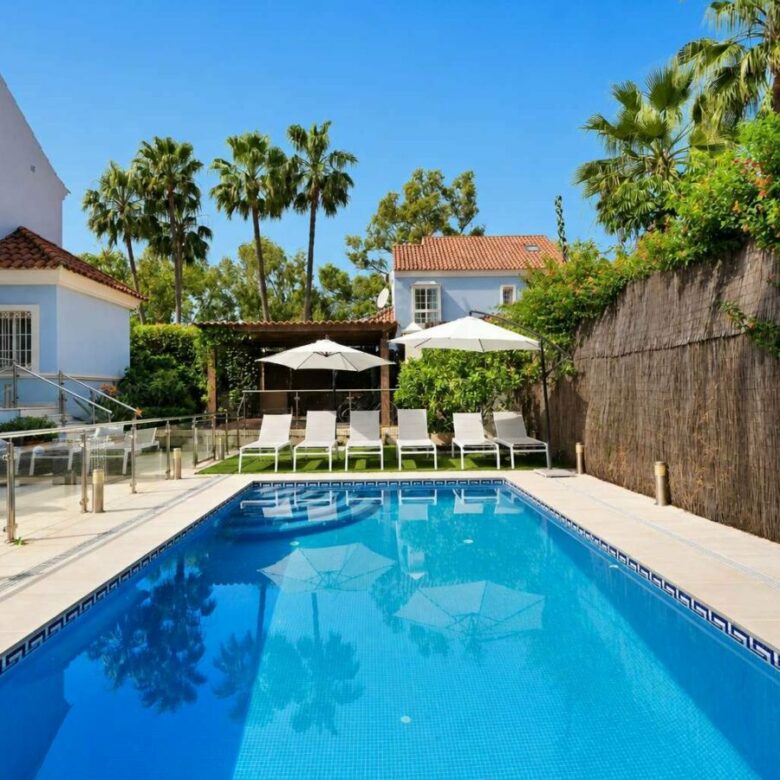 Heated swimming pool, sun loungers and landscaped garden of the Lorea Playa villa
