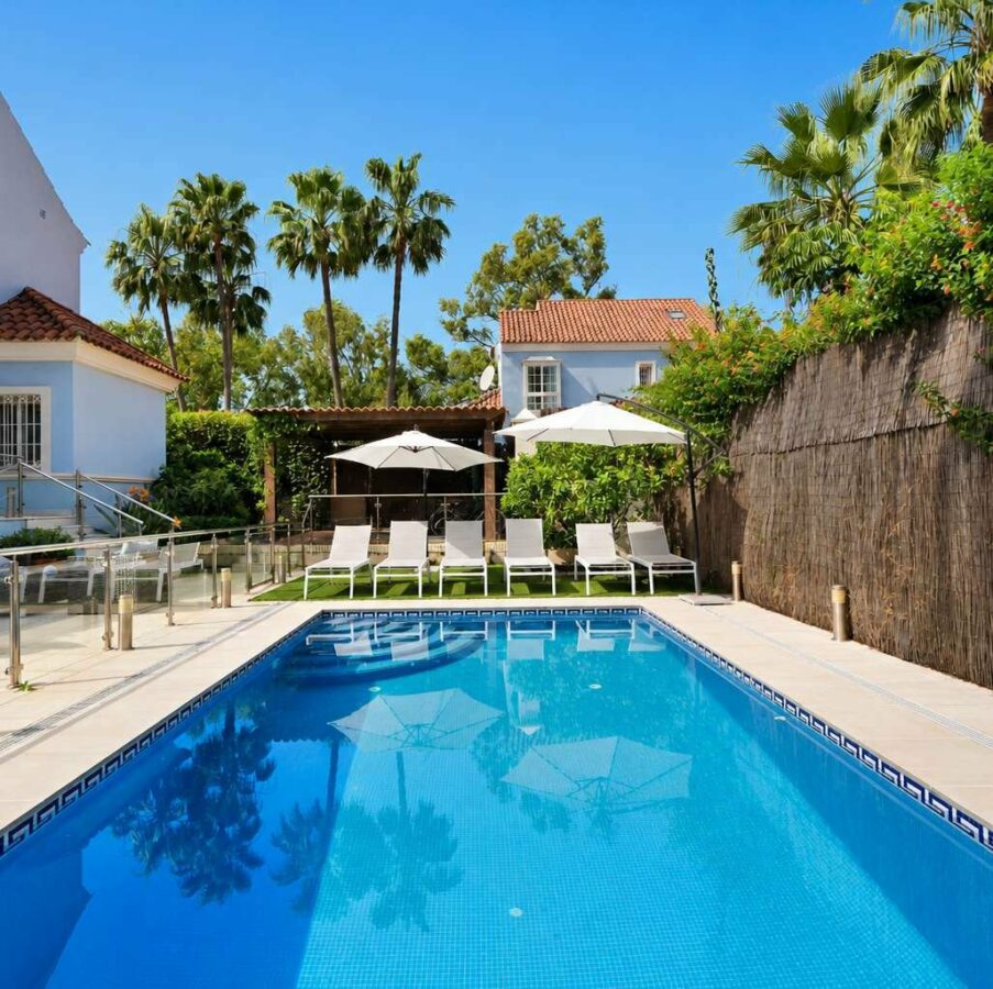 Heated swimming pool, sun loungers and landscaped garden of the Lorea Playa villa